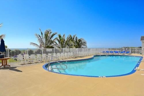 a swimming pool with chairs and a fence at Carousel 1904 in Ocean City
