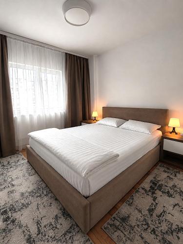 a bedroom with a large bed and a large window at Adrian Home, Central in Ploieşti
