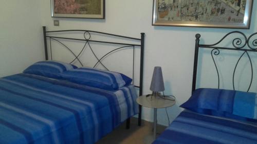 ガリポリにあるVilla Graziellaのベッドルーム1室(青いシーツとランプ付きのベッド2台付)