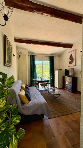 a living room with a couch and a table at Les Oliviers in Grimaud