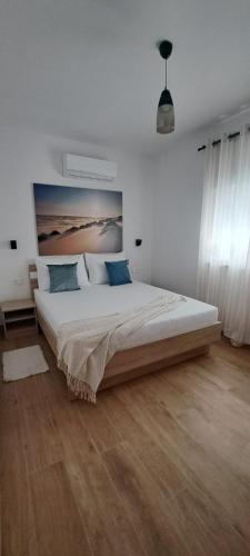 a bedroom with a large bed in a white room at DaVita in Novalja
