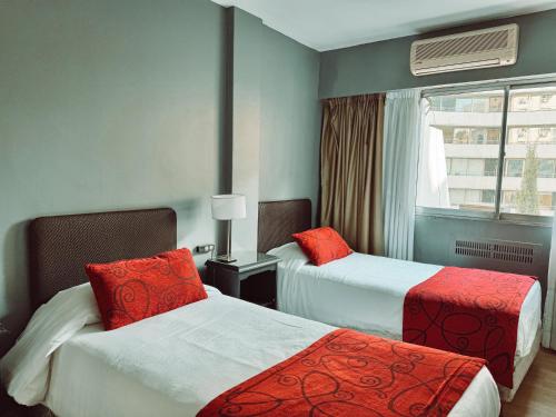 a hotel room with two beds and a window at Gran Hotel Buenos Aires in Buenos Aires