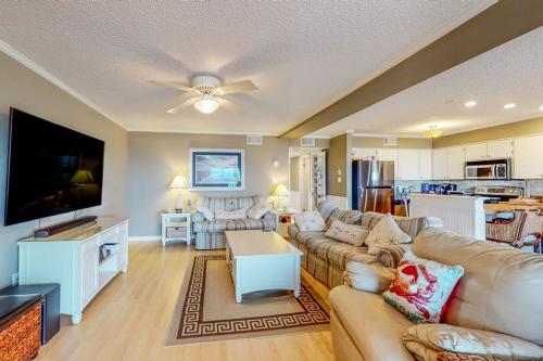 a living room with a couch and a flat screen tv at Our Place At The Beach 206B in Ocean City