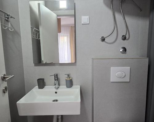 a bathroom with a sink and a mirror at Vele House Walk to Beach in Herceg-Novi