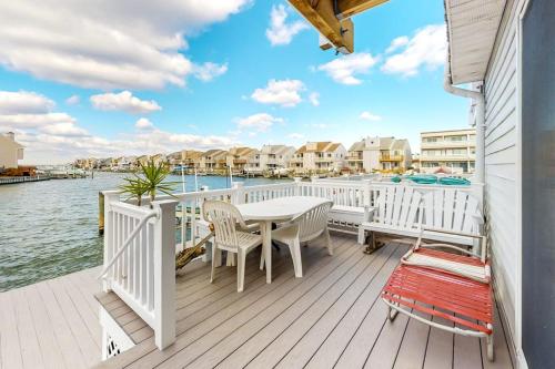 a deck with a table and chairs and the water at Gullway Getaway in Ocean City