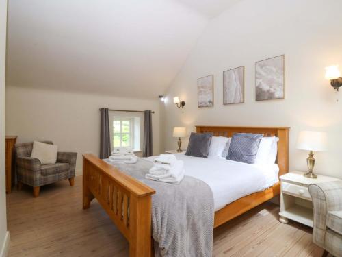 a bedroom with a large bed with towels on it at No 2 The Stables in Llangefni