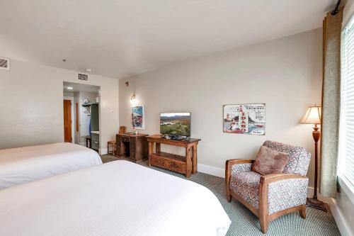 a bedroom with two beds and a chair and a desk at Hotel McCall in McCall