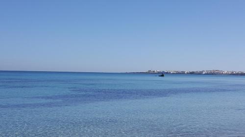 a large body of water with a boat in it at Appartement Vue Sur Mer Turquoise in Mahdia