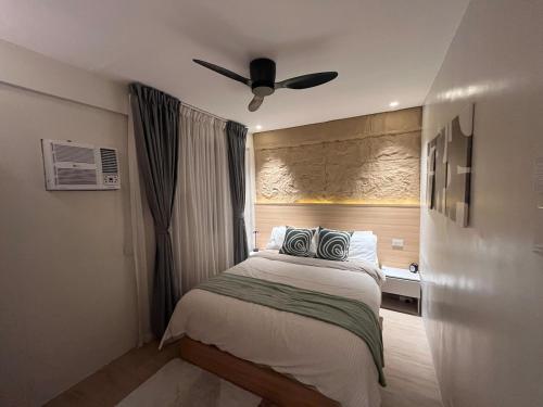 a bedroom with a bed with a ceiling fan at CHL Pod in General Trias