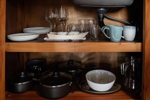 a shelf with plates and bowls and other dishes at Pousada Quinta do Cangueri in Imaruí