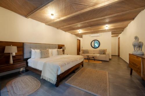 a bedroom with a large bed and a couch at Quinta San Carlos in San Pedro Tesistán