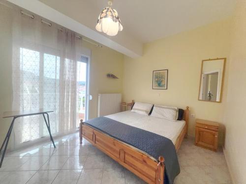 a bedroom with a bed and a large window at An-Mary by vacapers in Iraklitsa