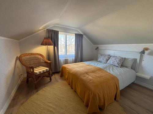 a bedroom with a bed and a chair and a window at Villa Emma in Alsterbro