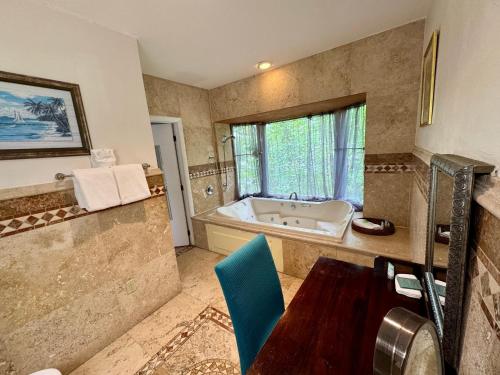 a bathroom with a tub and a table and a chair at Coconut Cove Resort & Marina in Islamorada