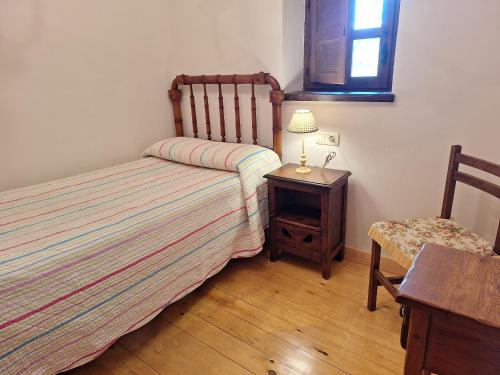 a bedroom with two beds and a table with a lamp at Casa Jacinta in Bimenes