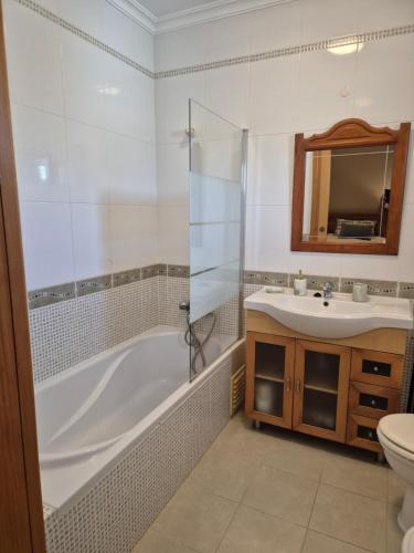 a bathroom with a tub and a sink and a toilet at CARAVELL ARMAÇÃO de PÊRA in Armação de Pêra
