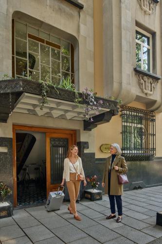 two women are standing outside of a building at Casa Malí by Dominion Boutique Hotel in Mexico City