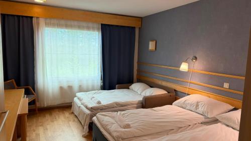 a hotel room with two beds and a window at Tiera Resort in Taivalkoski