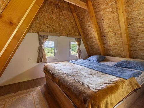 a bedroom with a large bed in a stone wall at Cottage by the brook in Plužine