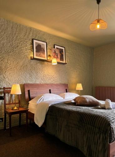 a bedroom with a large bed and two lamps at Relais du Moulin - Bed & Breakfast in Abreschviller