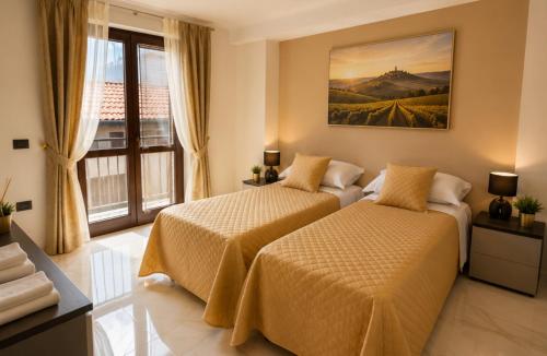 a bedroom with two beds and a large window at Da Mario in Guarene