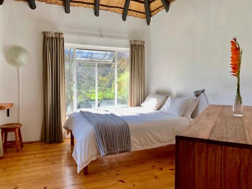 a bedroom with a white bed and a window at Forestiva Farm - River Cottage in Centurion