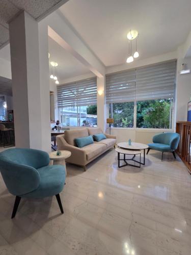 ein Wohnzimmer mit Sofa, Stühlen und Tischen in der Unterkunft Avra Beach Hotel in Nydri