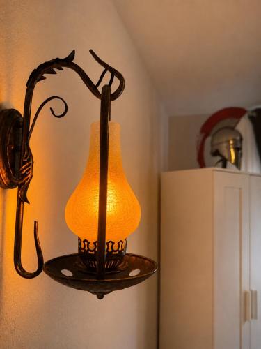 a lamp hanging from a wall next to a refrigerator at César Room - Appartement Antique 2-3 pers, parking privé,proche centre et gare in Obernai