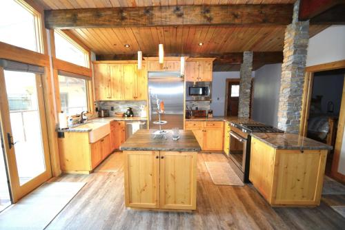 a large kitchen with wooden cabinets andsteel appliances at Deer Lodge #2- Lake Front in Bass Lake