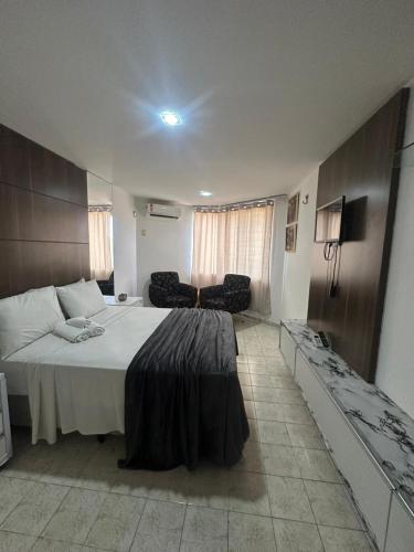 a bedroom with a large bed and a couch at Hotel Victory flat in Cabedelo