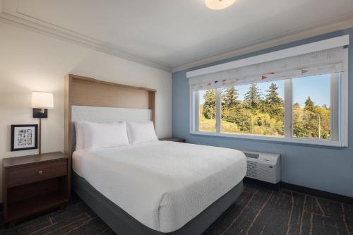 a bedroom with a large bed and a window at Holiday Inn Victoria - Elk Lake by IHG in Victoria