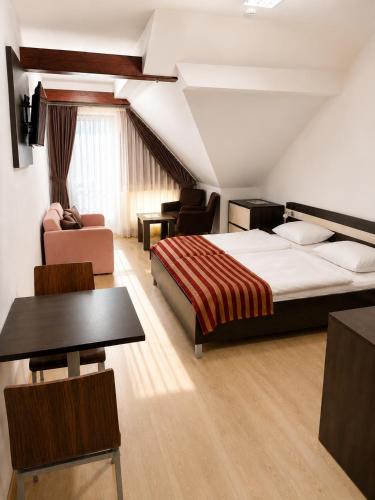 a hotel room with a bed and a table and chairs at Komnata Bešeňová - Apartmán 344 in Bešeňová