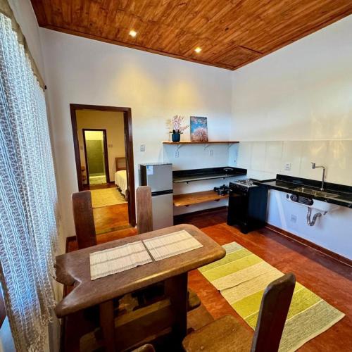 a kitchen with a table and a dining room at Pousada Kokopelli in Lavras Novas