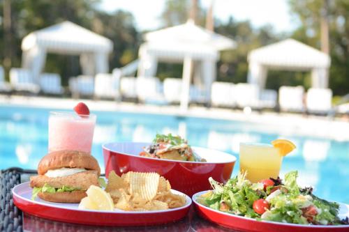 a table with two plates of food next to a pool at Montage Palmetto Bluff in Bluffton