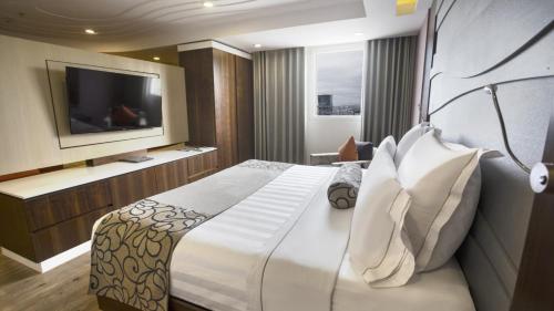 a hotel room with a bed and a television at HS HOTSSON Hotel Queretaro in Querétaro