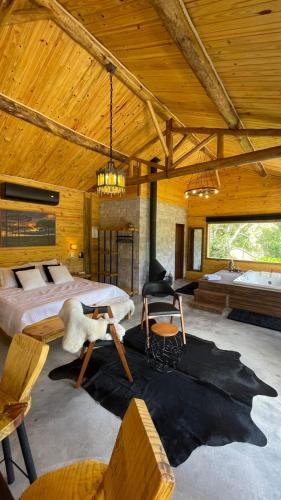 a large bedroom with a bed and a couch at Chalés Rancho Queimado in Rancho Queimado