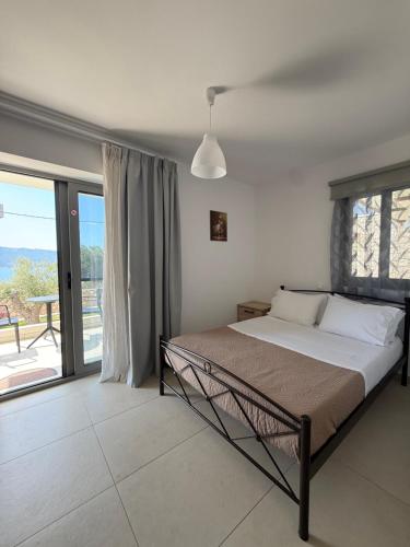 a bedroom with a bed and a large window at Elements Villas in Paleros