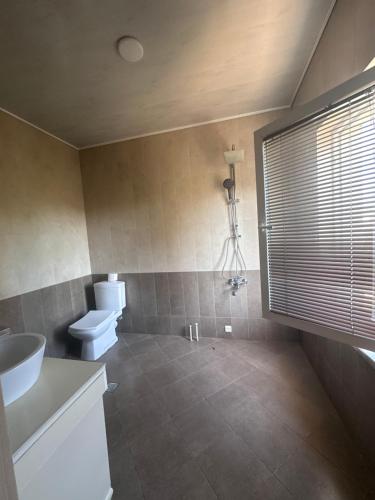 a bathroom with a sink and a toilet and a window at Kobuleti 327 a in Kobuleti