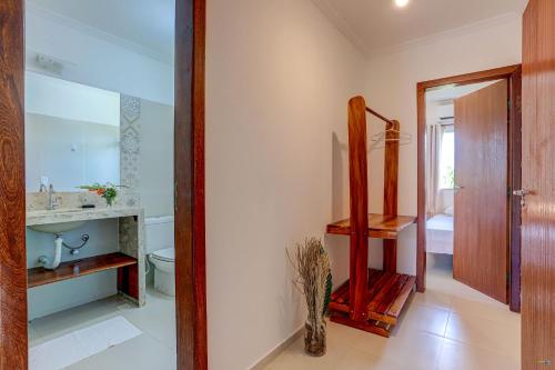 a bathroom with a toilet and a sink and a mirror at Casabela Sargi Serra Grande in Uruçuca