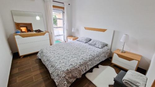 ein kleines Schlafzimmer mit einem Bett und einem Spiegel in der Unterkunft Cocoon pour 6 personnes in Mirandela
