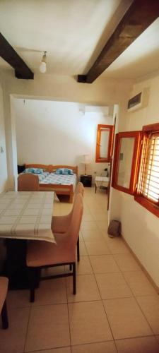 a room with a table and chairs and a bed at Oasis - Oaza in Sutomore