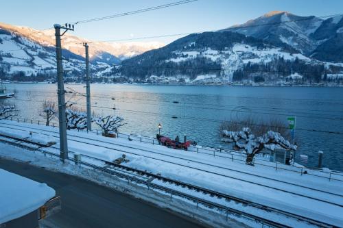 a view of a lake with snow covered mountains at Hotel Seehof in Zell am See