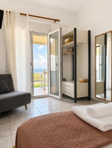 a bedroom with a bed and a sliding glass door at Starry Coast Apartments in Nea Potidaea