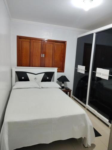 a bedroom with a white bed and a large window at casa de temporada em Piranhas ótimo lugar e conforto lila in Piranhas