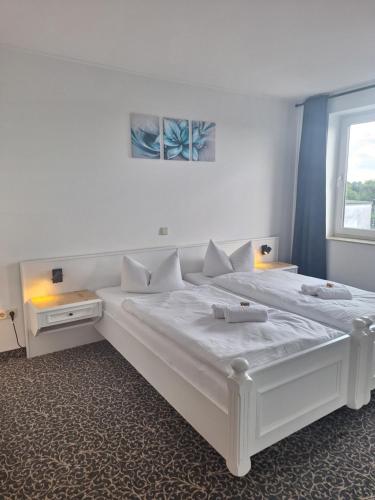 a large white bed in a room with a window at Hotel am Zellwald in Großschirma