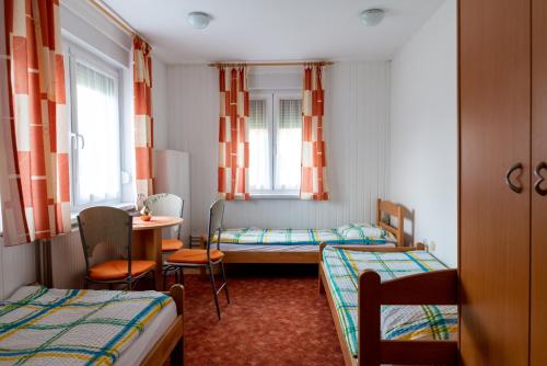 a small room with two beds and a table at Hostel 1550 in Moravske-Toplice