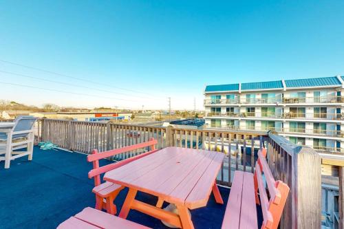 a wooden table and chairs on a deck with a building at North Point Condo 301 in Ocean City