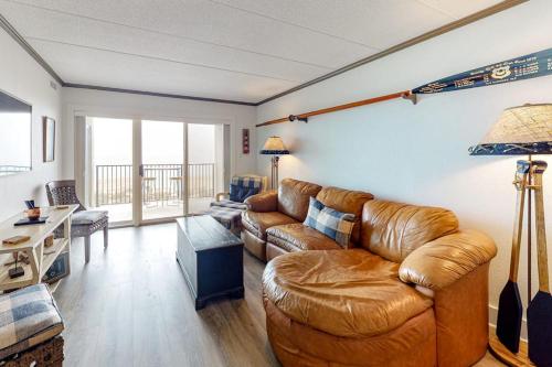 a living room with a leather couch and a table at Marigot Beach Condo in Ocean City