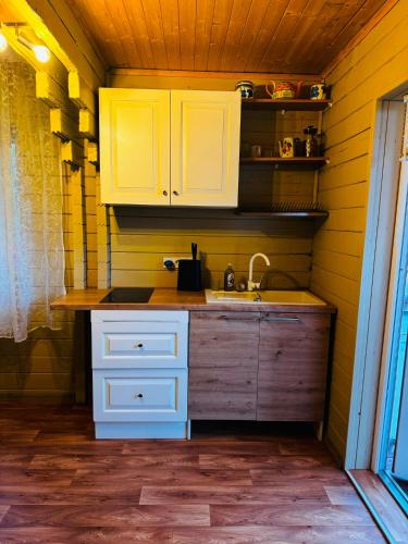 a kitchen with white cabinets and a sink at River Kemping in Jūrmala