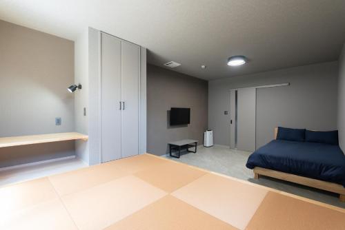 a bedroom with a blue bed and a television at HOTEL PG3 - Vacation STAY 46492v in Habu
